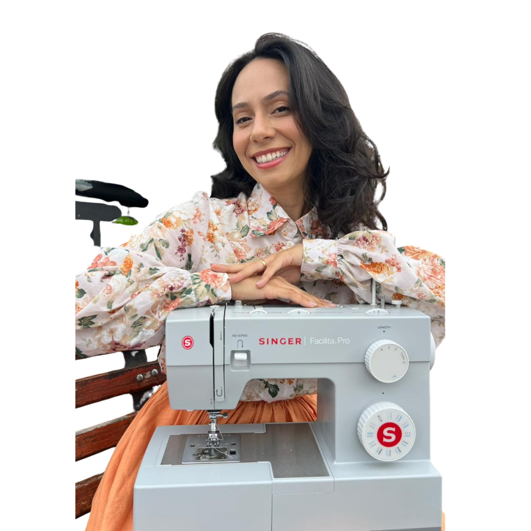 Aluna apoiada na máquina de costura, sorrindo