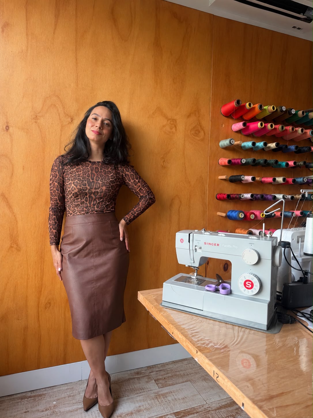 Conjunto Saia Reta + Blusinha no ateliê, ao lado da máquina de costura e da parede de linhas